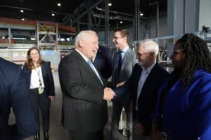 Business leaders and officials shaking hands at an energy cooperation event, promoting security and collaboration in the energy sector under the Am-can Energy Cooperation and Security initiative.