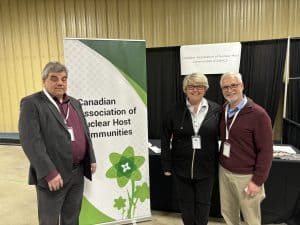 Group photo of three professionals at the ARMA conference, showcasing networking and collaboration in nuclear and radioactive waste management, with ARMA branding in the background.